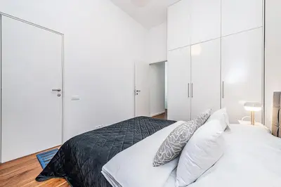 a bedroom with white cabinets and a bed with pillows at Stunning 2 bed in prime central location in Prague