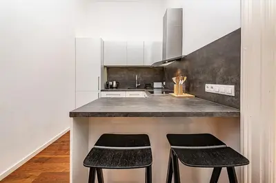 a kitchen with two black stools at a counter at Stunning 2 bed in prime central location in Prague