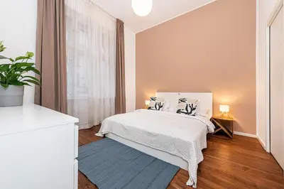 a white bedroom with a bed and a window at Stunning 2 bed in prime central location in Prague