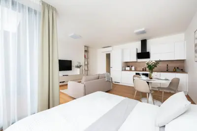 a white bedroom with a kitchen and a dining room at Prague Modern Apartment in Prague