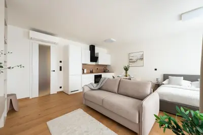 a white living room with a bed and a couch at Prague Modern Apartment in Prague