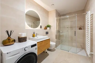 a bathroom with a washing machine and a shower at Prague Modern Apartment in Prague