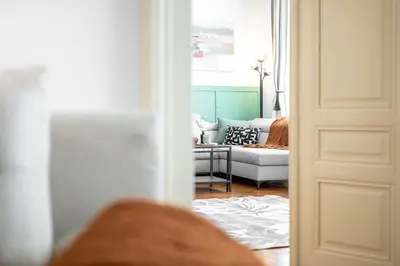 a door leading into a living room with a couch at Trendy Apt Centrally Located with PS5, AC, balcony in Prague