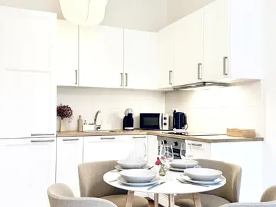 a kitchen with white cabinets and a table and chairs at Peaceful Apartment near City in Prague