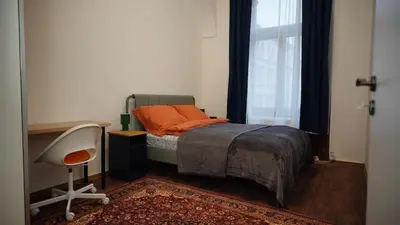 a bedroom with a bed and a desk and a window at Spacious 2 Bedroom Apartment in Prague 2 in Prague