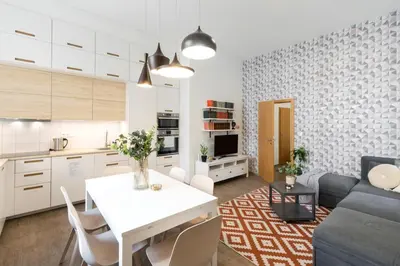 a kitchen and a living room with a table and a couch at Central 2 Bedrooms Apartment with Living Room & Parking - Near Wenceslas Square & Main Train Station in Prague