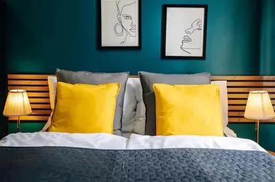 a bedroom with a bed with two yellow pillows at Spacious 3BR Apartment with Billiards & Cinema in Prague