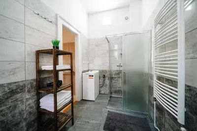a bathroom with a shower and a glass shower stall at Spacious 3BR Apartment with Billiards & Cinema in Prague
