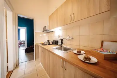 a kitchen with a sink and a counter with plates on it at Spacious 3BR Apartment with Billiards & Cinema in Prague