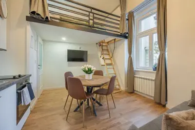a dining room with a table and chairs and a loft bed at HOMELY I BIG Central APTI ELEVATOR I Self Check-In in Prague