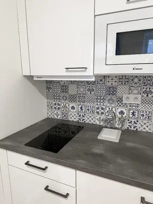 a kitchen with white cabinets and a microwave at REAL Living by REFA - New Town 210 in Prague