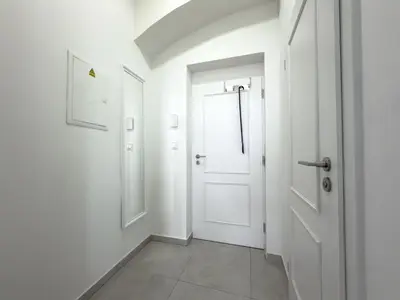a hallway with a white door and a window at REAL Living by REFA - New Town 210 in Prague