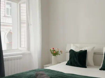 a white bedroom with a bed and a window at REAL Living by REFA - New Town 210 in Prague