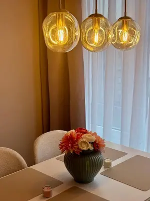 a vase with flowers on a table with lights at My Sweet Home - Makedonská - Prague in Prague