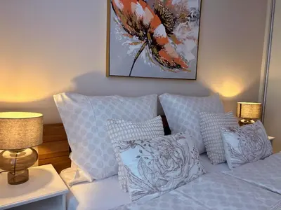 a bedroom with a bed with pillows and a painting at My Sweet Home - Makedonská - Prague in Prague