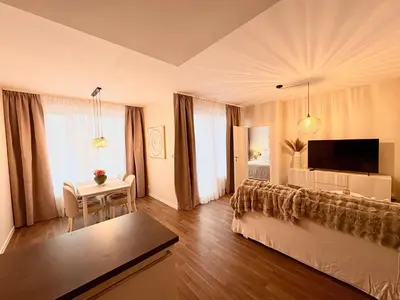 a large living room with a bed and a tv at My Sweet Home - Makedonská - Prague in Prague