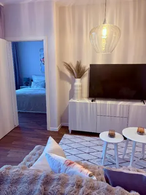 a living room with a couch and a tv and two tables at My Sweet Home - Makedonská - Prague in Prague