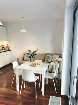 a white dining room table with white chairs and a couch at Fortuna Garden III in Prague