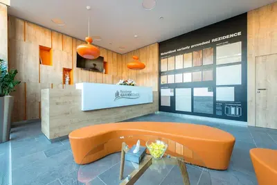 a living room with an orange couch and a table at Fortuna Garden III in Prague