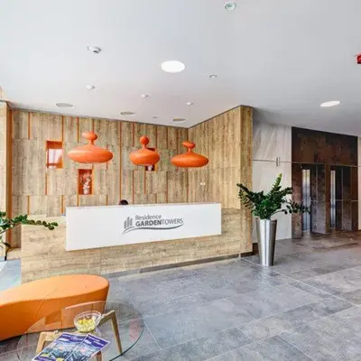 a lobby with orange chairs and a sign on the wall at Fortuna Garden III in Prague
