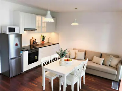 a kitchen and living room with a table and a couch at Fortuna Garden III in Prague