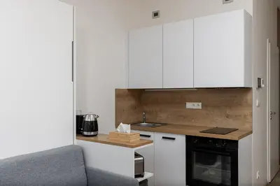 a kitchen with white cabinets and a sink and a stove at Modern Apartment Near Anděl & Metro in Prague