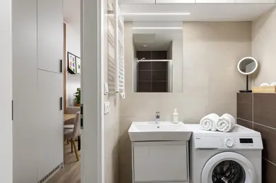 a bathroom with a washing machine and a sink at Modern Apartment Near Anděl & Metro in Prague