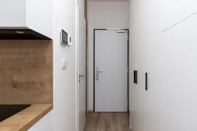 a hallway with two white doors in a kitchen at Modern Apartment Near Anděl & Metro in Prague