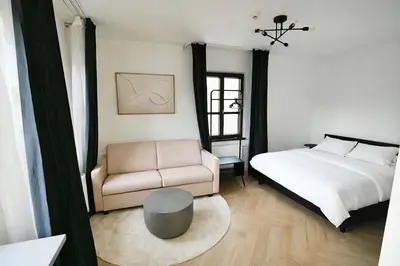 a bedroom with a bed and a couch and a chair at Modern apartment near Wenceslas square in Prague