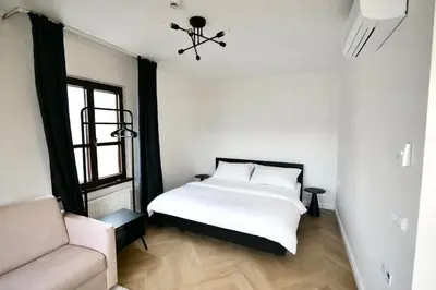 a bedroom with a white bed and a couch at Modern apartment near Wenceslas square in Prague