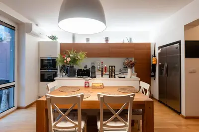 a kitchen and dining room with a wooden table and chairs at QUIET apartment with FREE parking & balcony in Prague