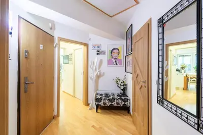 a hallway with a mirror and a room with a table at QUIET apartment with FREE parking & balcony in Prague