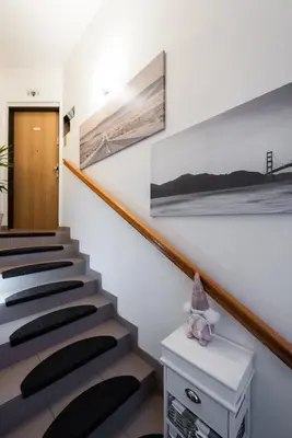 a staircase in a house with paintings on the wall at QUIET apartment with FREE parking & balcony in Prague