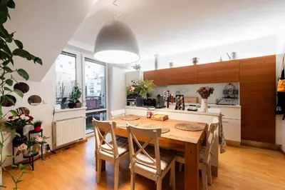 a kitchen and dining room with a wooden table and chairs at QUIET apartment with FREE parking & balcony in Prague
