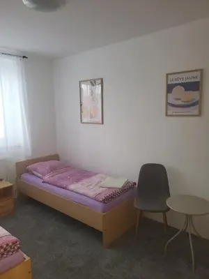 a bedroom with a bed and a chair and a table at Komárov Apartment 3 in Komárov