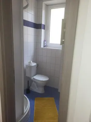a bathroom with a white toilet and a window at Komárov Apartment 3 in Komárov