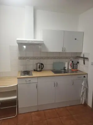 a kitchen with white cabinets and a sink at Komárov Apartment 3 in Komárov