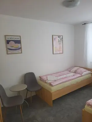 a bedroom with a bed and two chairs and a table at Komárov Apartment 3 in Komárov