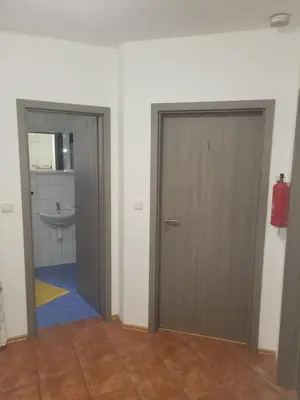 two doors in a bathroom with a sink and a toilet at Komárov Apartment 3 in Komárov