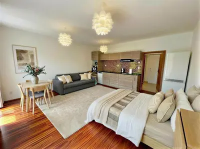 a bedroom with a large bed and a living room at Fortuna Garden IV in Prague