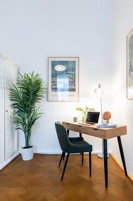 a desk with a laptop and a chair in a room at Prague Days - Apartments with Parking in New Town in Prague