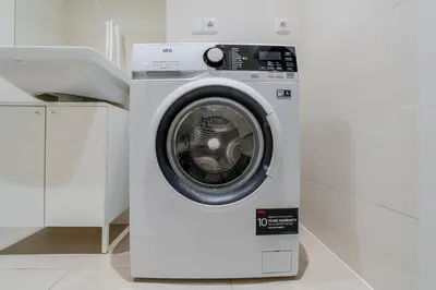 a white washing machine in a white laundry room at Blueground Vršovice view nr Vyšehrad PRG-84 in Prague