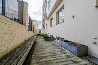 a walkway between two buildings with a wooden bench at Blueground Vršovice view nr Vyšehrad PRG-84 in Prague