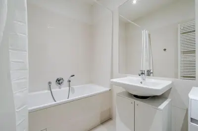 a white bathroom with a sink and a bath tub at Blueground Vršovice view nr Vyšehrad PRG-84 in Prague