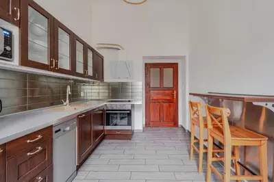 a kitchen with wooden cabinets and a table and chairs at Blueground Malá Strana view nr Prague Castle PRG-94 in Prague