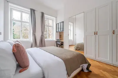 a white bedroom with a large bed and windows at Blueground Malá Strana view nr Prague Castle PRG-94 in Prague