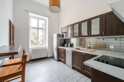 a kitchen with wooden cabinets and a refrigerator at Blueground Malá Strana view nr Prague Castle PRG-94 in Prague