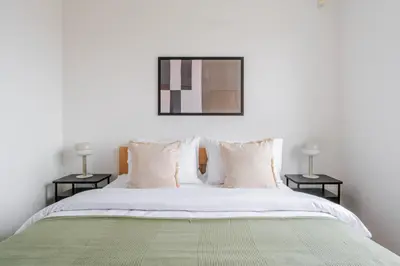 a bedroom with a white bed with two tables at Blueground Vinohrady pool nr Vyšehrad PRG-88 in Prague
