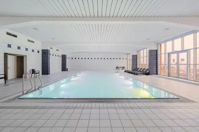 a swimming pool in a large room with windows at Blueground Vinohrady pool nr Vyšehrad PRG-88 in Prague