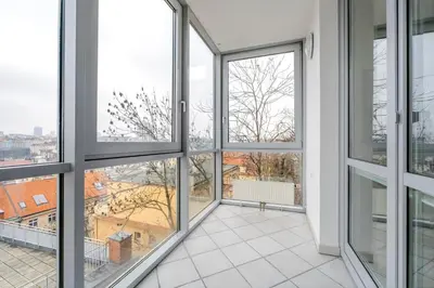 an empty room with windows and white tile floors at Blueground Vinohrady pool nr Vyšehrad PRG-88 in Prague